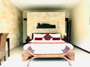 a bedroom with a large bed and a brick wall at Dream Villa Carissa Seminyak Centre in Seminyak