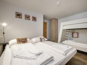 una camera da letto con un grande letto con lenzuola bianche di Hirnreit a Leogang