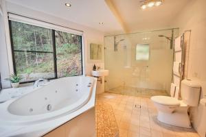 a bathroom with a tub and a toilet and a shower at EcOasis in Uki