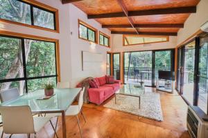 sala de estar con mesa de cristal y sofá rojo en EcOasis, en Uki