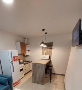 a small kitchen with a table and a refrigerator at Departamento Las3B 5 in General Roca