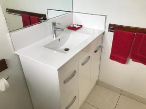 a bathroom with a white sink and a mirror at Ocean Breeze Units in Bowen