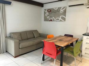 a living room with a couch and a table and chairs at Ocean Breeze Units in Bowen