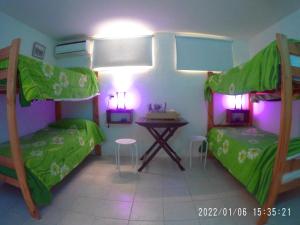 a bedroom with two bunk beds and a table at COMPLEJO ALOHA in Puerto Pirámides