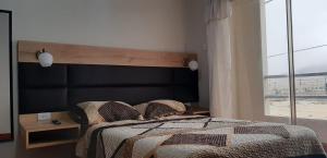 1 dormitorio con 1 cama grande y ventana grande en Hospedaje Costa Malabrigo, en Puerto Chicama