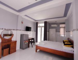 a bedroom with a bed and a desk in it at NGỌC QUÝ Mini House in Quy Nhon