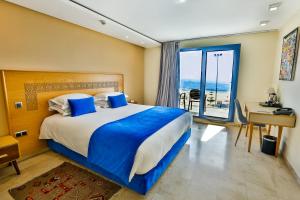 a bedroom with a bed with a view of the ocean at Hotel Cote ocean Mogador in Essaouira