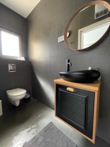 een badkamer met een zwarte wastafel en een spiegel bij SEA& SUN in H̱adera