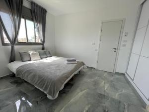 - une chambre avec un lit et une grande fenêtre dans l'établissement SEA& SUN, à Hadera