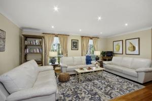 a living room with two white couches and a table at Hilldo in Kurrajong