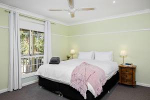 a bedroom with a bed with a pink blanket on it at Hilldo in Kurrajong