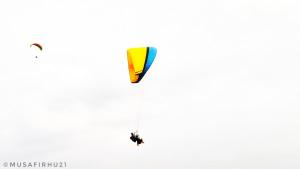 a person flying a kite in the sky at BASERAA BIR - A Slow Traveler's Home in Bīr +26 photos