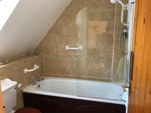 a bath tub in a bathroom with a shower at Lower Mill 2 Cottage Broadway in Broadway +28 photos