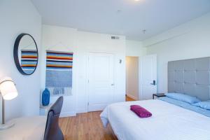 a white bedroom with a bed and a mirror at 3BD 1,5BTH Spacious Apt in Mission Hill in Boston