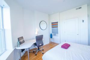 una camera con letto, scrivania e computer di 3BD 1,5BTH Spacious Apt in Mission Hill a Boston