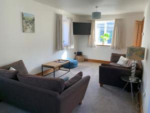 uma sala de estar com dois sofás e uma mesa em Dawsons Cottage em Lancaster