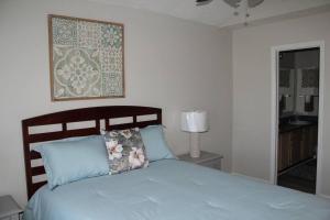 um quarto com uma cama azul e uma fotografia na parede em Cheerful 2-Bedroom, 2 bath with private parking em Fayetteville