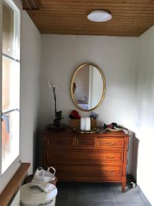 a bathroom with a wooden dresser and a mirror at Simple flat in the centre of Burgdorf - 72 m2 with private parking in Burgdorf