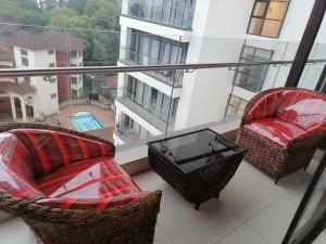 un balcón con 2 sillas y una mesa en un edificio en Lavington Cosy Homes, en Nairobi