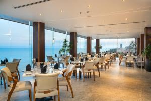 a restaurant with tables and chairs and the ocean at Regal Réseau Hotel & Spa in Negombo