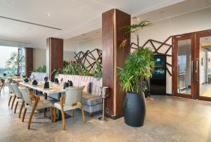 a dining room with a table and chairs and plants at Regal Réseau Hotel & Spa in Negombo