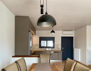 a dining room with a table and a black light fixture at KYRIAKOS APPARTMENT in Monemvasia