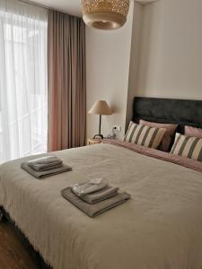 um quarto com uma cama grande com toalhas em Jorė em Juodkrantė