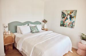 a bedroom with a white bed and a painting on the wall at Houston Beachfront Apartments in Gold Coast +83 photos