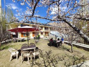 列城的住宿－Snow Lion Ladakh，一群人坐在桌子上,拿着雨伞