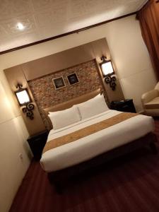 sypialnia z łóżkiem i ceglaną ścianą w obiekcie Royal Castle w Rahimjar Khan