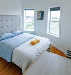a bedroom with a bed with a yellow towel on it at 4BR 1,5BH Comfy Newly Renovated Apt in Boston