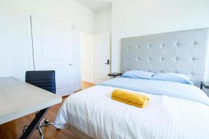 a bedroom with a bed with a yellow towel on it at 4BR 1,5BH Comfy Newly Renovated Apt in Boston