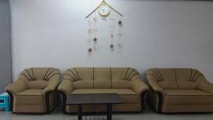 uma sala de espera com duas cadeiras e um relógio na parede em Coastside Homestay em George Town