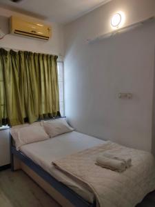 een bed in een kamer met een groen gordijn bij PRAVESH VILLA in Pondicherry
