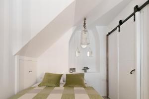 a bedroom with white walls and a bed with green pillows at Corfu Old Town Studio in Corfu Town