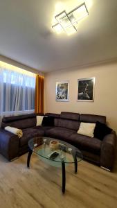 a living room with a couch and a glass table at Mazurski apartament in Ostróda