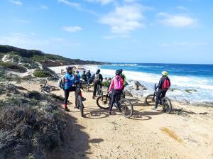 - un groupe de personnes à vélo sur une plage dans l'établissement Bed and Bike Antico Mulino, à Aglientu