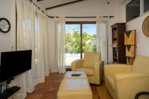 a living room with yellow chairs and a television at Casa Colina in Albir