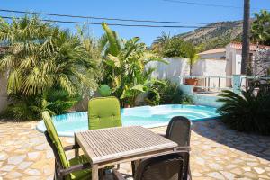 a table and chairs next to a swimming pool at Casa Colina in Albir