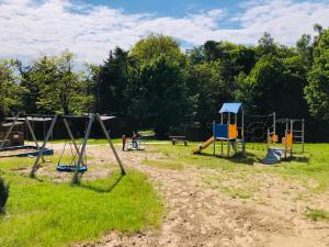 a park with two swings and a playground at Domki Skowronki in Kąty Rybackie