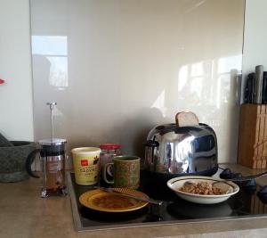una barra de cocina con tostadora y un tazón de comida en Kiwi Heritage Homestay, en Auckland