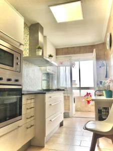 a kitchen with stainless steel appliances and a table at TUDELA CENTRO-Teatro Gaztambide-3 habitac. in Tudela