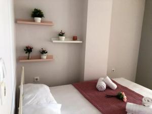 a small room with a bed with towels on it at Pink Rose Apartment in Néa Péramos