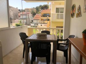 a dining room table and chairs on a balcony at Pink Rose Apartment in Nea Peramos