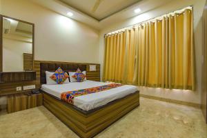 ein Schlafzimmer mit einem großen Bett und einem Spiegel in der Unterkunft FabExpress Sunshine in Gauripur