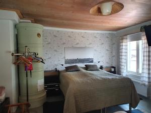sypialnia z łóżkiem i drewnianym sufitem w obiekcie Siirilän tila w mieście Seinäjoki