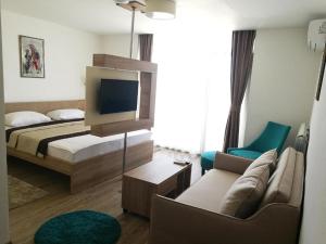 a bedroom with a bed and a tv and a couch at Hotel Onogošt in Nikšić