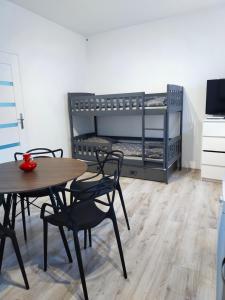 Habitación con mesa, sillas y litera en Apartament Przy rynku, en Duszniki-Zdrój