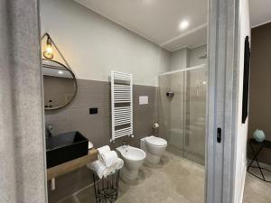 La salle de bains est pourvue d'un lavabo, de toilettes et d'un miroir. dans l'établissement Opuntia rooms, à Milazzo