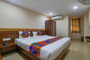1 dormitorio con 1 cama grande con una manta colorida en FabHotel Pishori en Indore